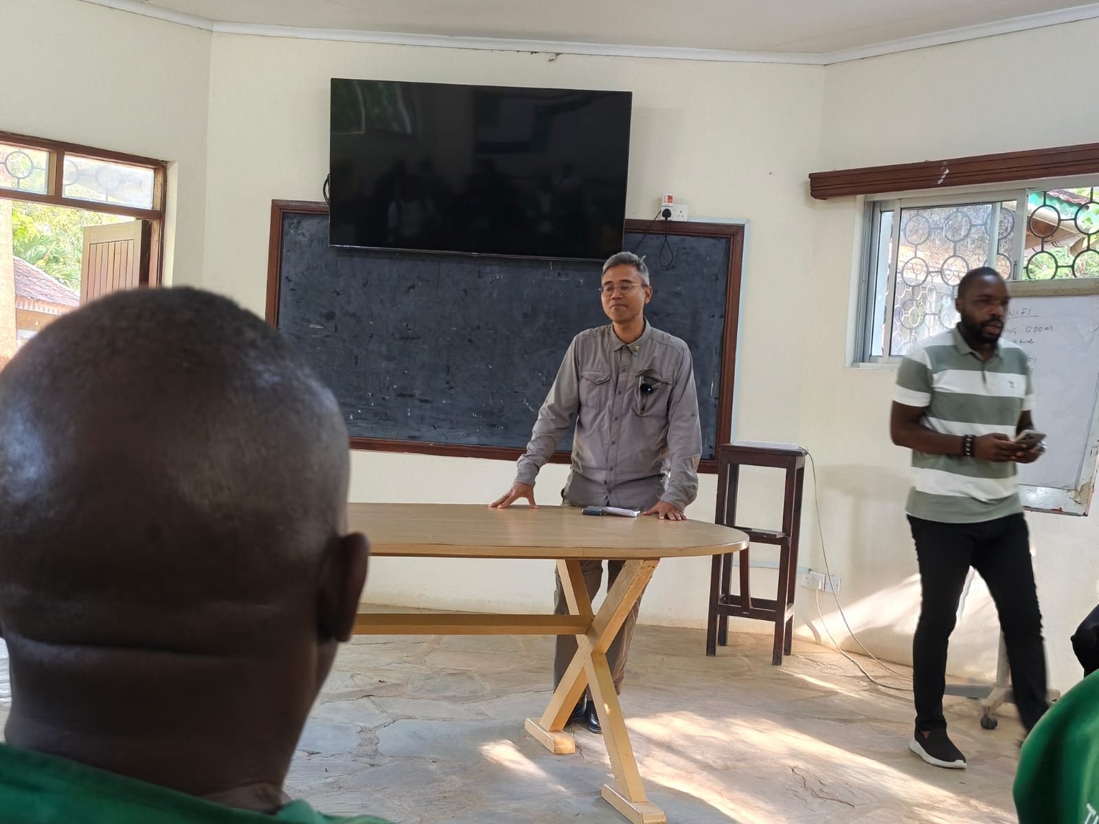 A technical session where a specialist briefs the restoration team in a community hall
